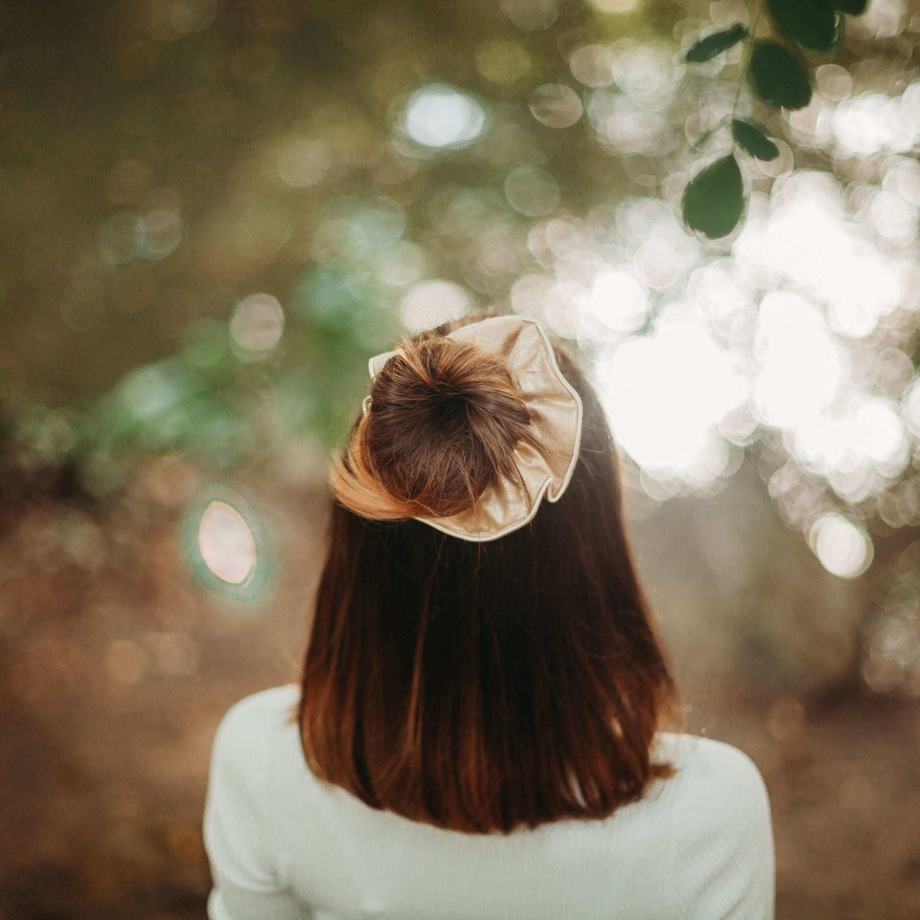 FEMME VUE DE DOS PORTANT UN CHOUCHOU ACCESSOIRE CHEVEUX EN LIN DORE