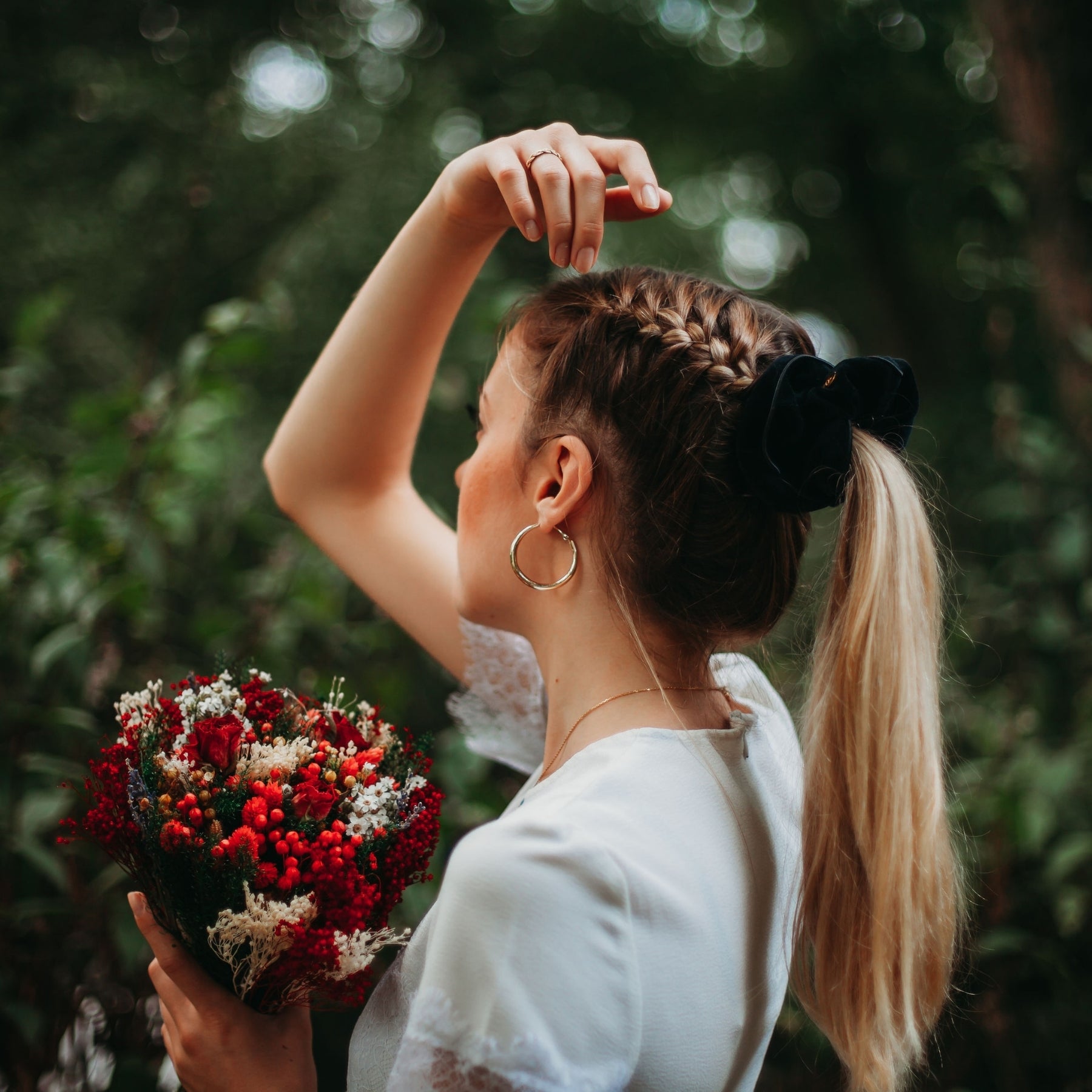 FEMME VUE DE PROFIL PORTANT UNE QUEUE DE CHEVAL RETENUE PAR UN CHOUCHOU CHEVEUX NOIR EN VELOURS DE COTON BIOLOGIQUE