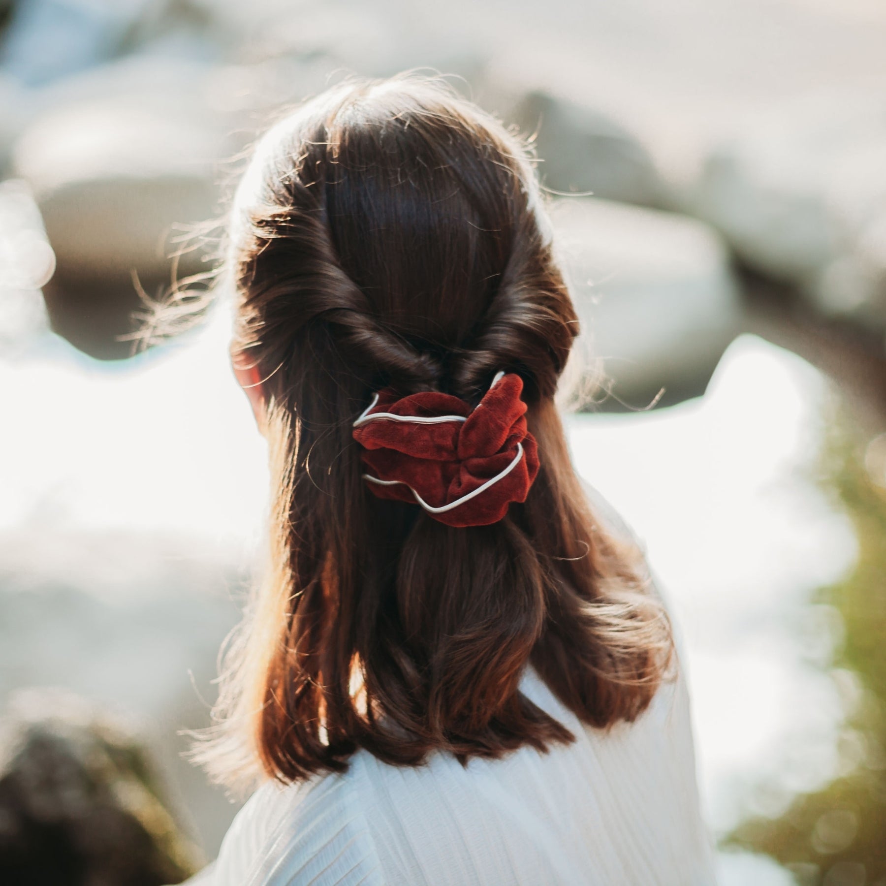 FEMME VUE DE DOS PORTANT UN CHOUCHOU DE COULEUR HENNE EN VELOURS DE COTON BIOLOGIQUE