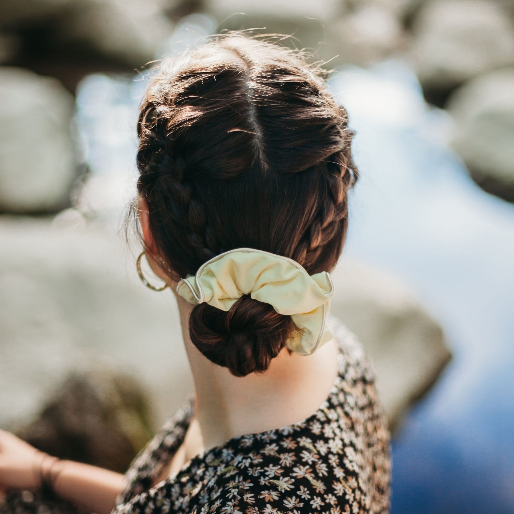 FEMME BRUNE VUE DE DOS PORTANT UN CHOUCHOU POUR CHEVEUX JAUNE EN COTON BIOLOGIQUE