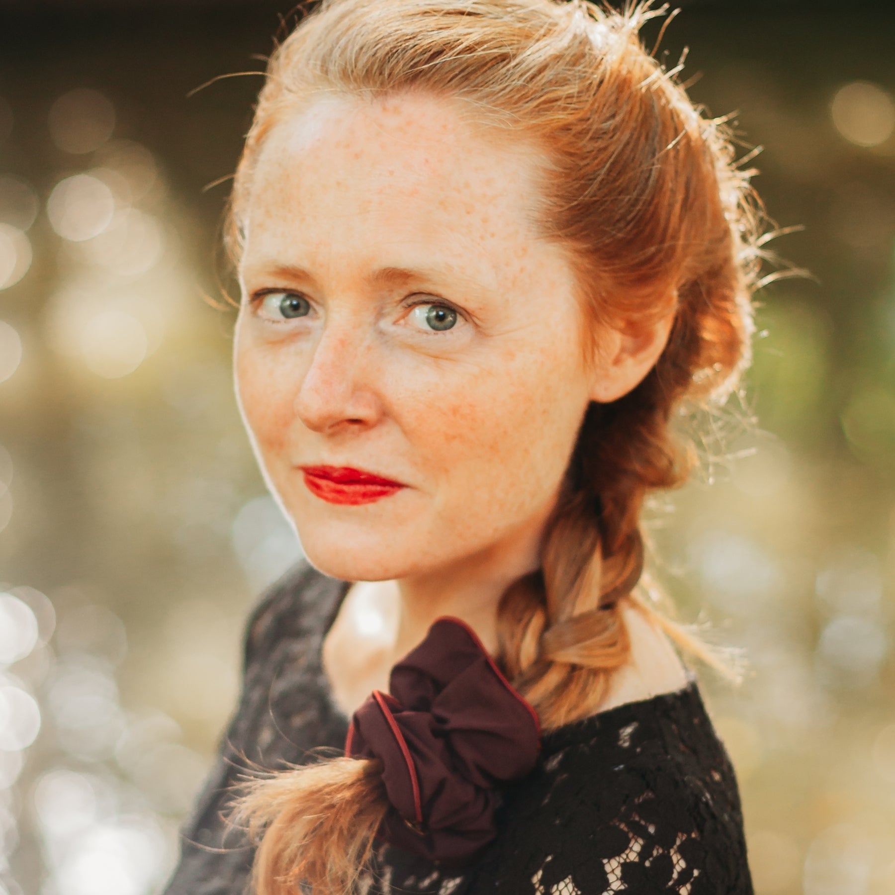 FEMME PORTANT UNE TRESSE RETENUE PAR UN CHOUCHOU BORDEAUX EN COTON BIOLOGIQUE