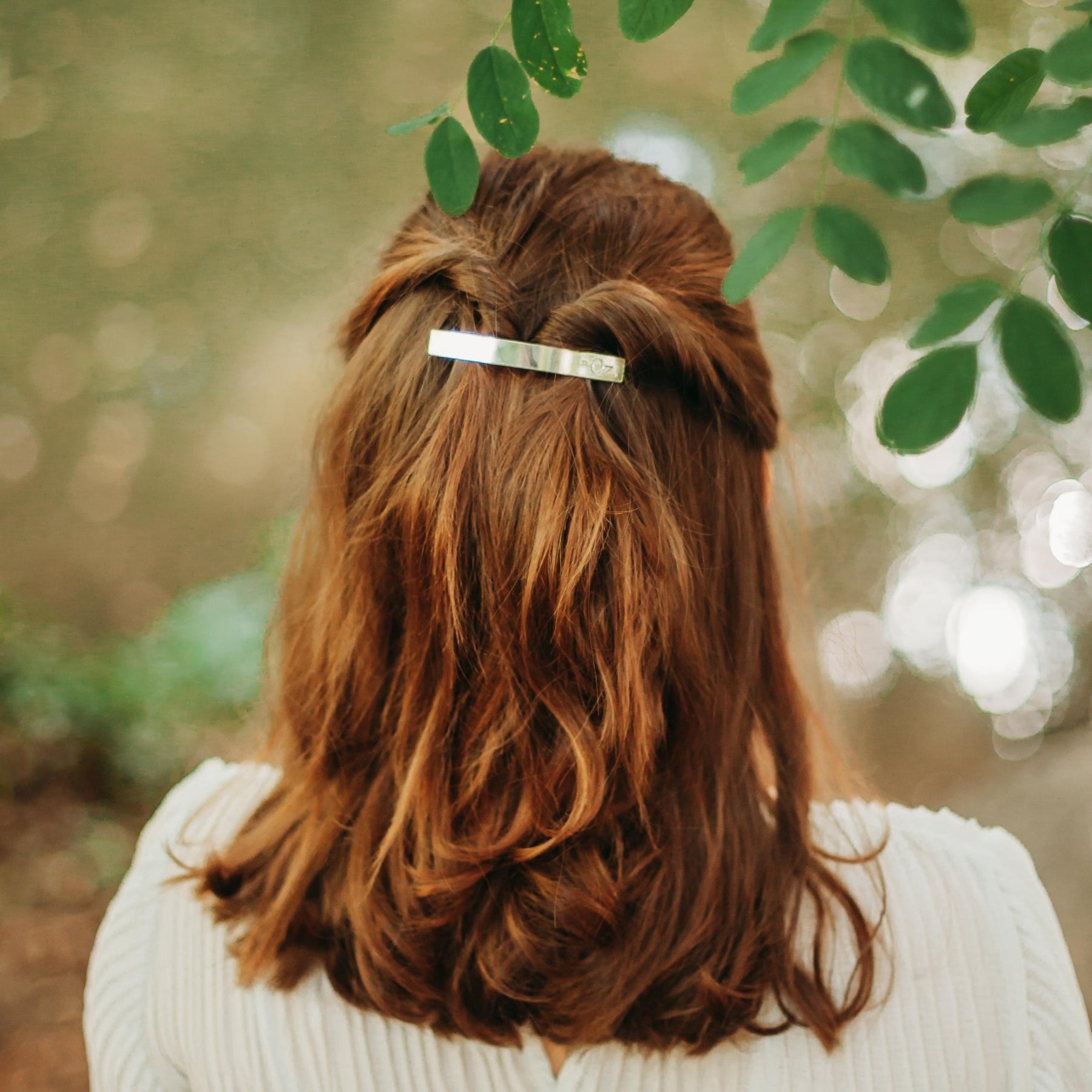 FEMME VUE DE DOS PORTANT UN BARRETTE ARGENTTEE