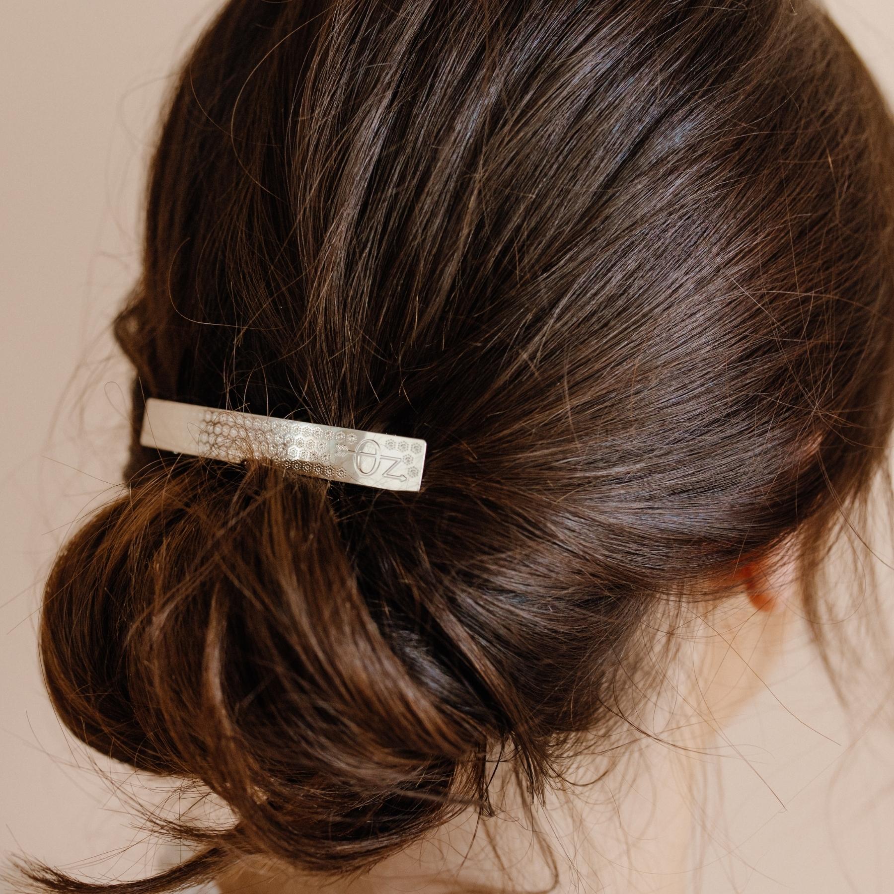 Chignon mariage simple élégant décoré d'une barrette cheveux argentée fleurie