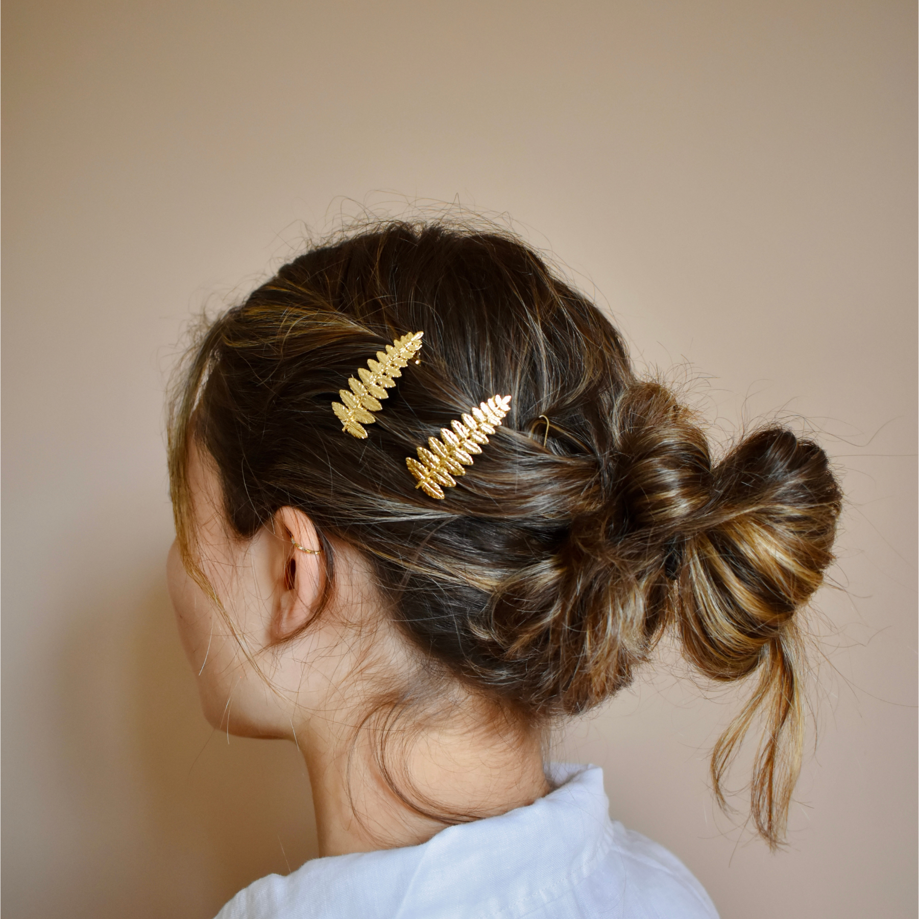 Coiffure femme décorée de barrettes à cheveux dorées feuille