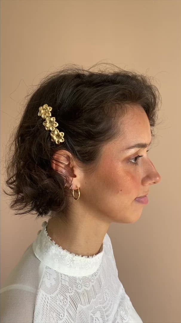 Femme cheveux courts et fins décorés d'une petite barrette dorée en métal 3 fleurs