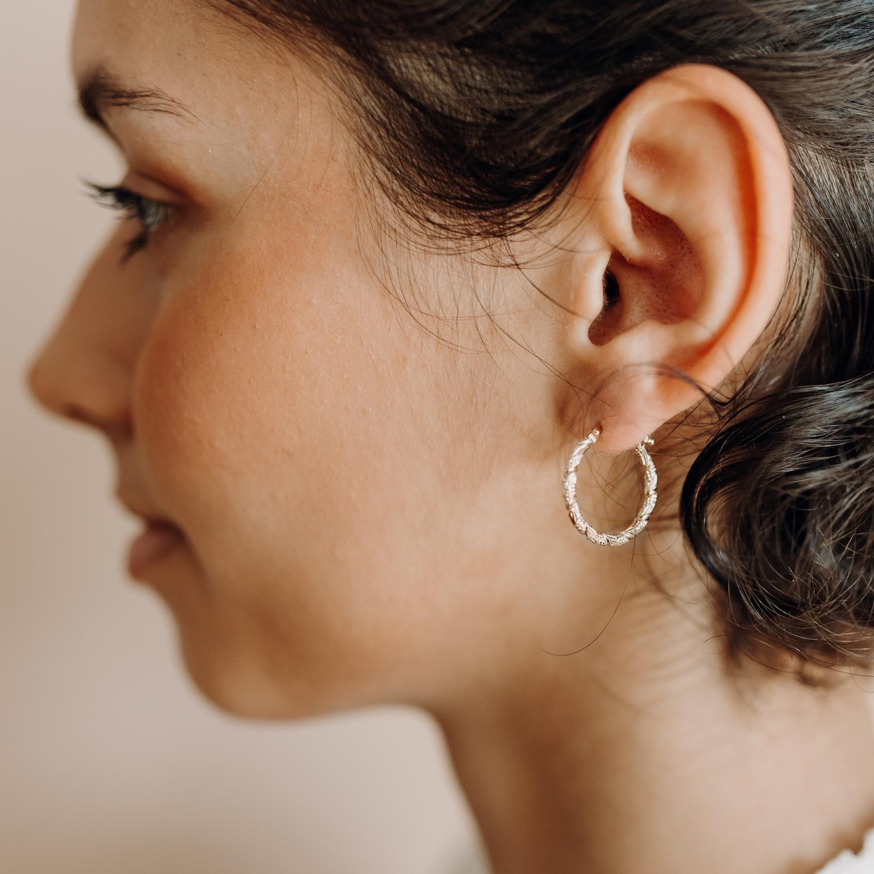 Boucles d'oreilles créoles moyennes argentées torsadées et gravées fait main en France