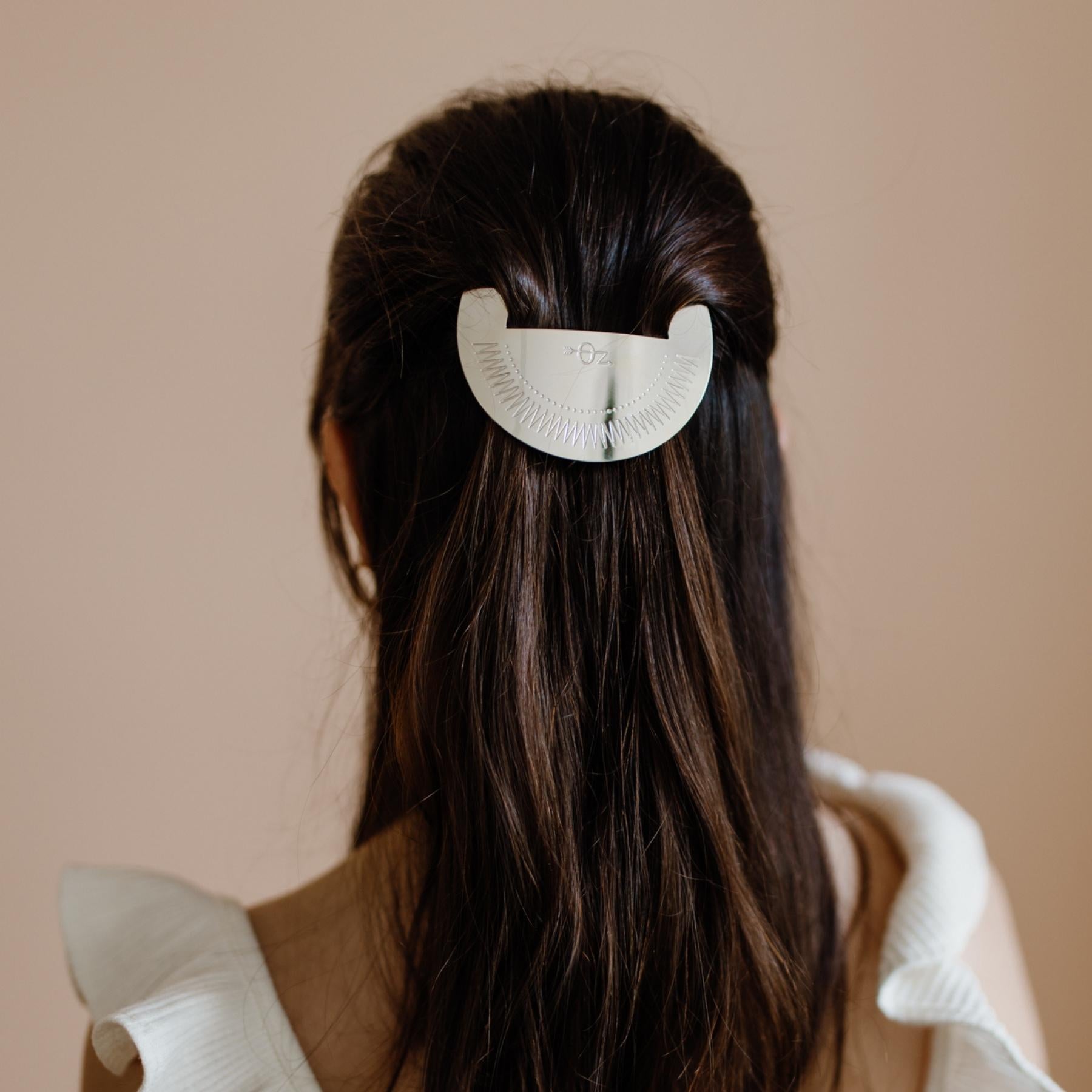 Femme aux cheveux longs portant une barrette ronde argentée